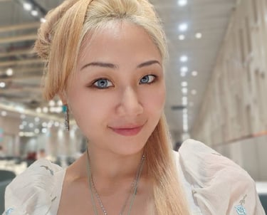 a woman with blonde hair and a necklace with a pendant