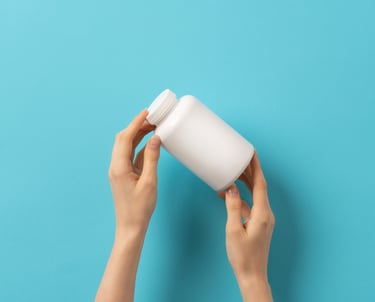 Una persona sosteniendo un bote de capsulas en sus manos
