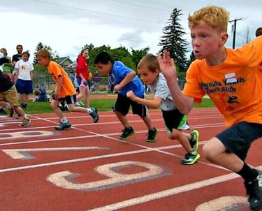 A photo of kids racing a track workout at a Race Ready Events Youth Coaching Clinic