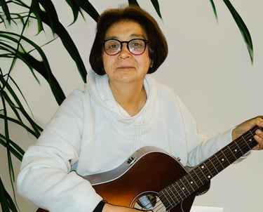 Diane Fischer holding a guitar