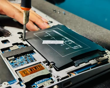 Un técnico utiliza un destornillador para reemplazar la batería de una computadora portátil y repara