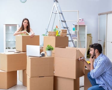 a man and woman moving boxes to move