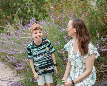Mother and son enjoy nature together surrounded by purple wildflowers in Lido , Madeira, natural family lifestyle mood
