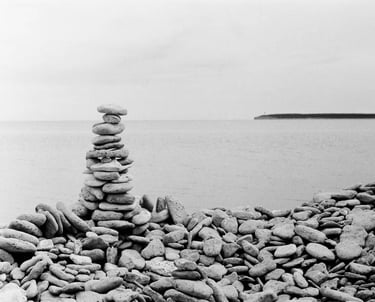 A monochrome image of a pile of stones on a stony beach