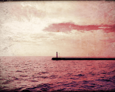 A lighthouse in the distance surrounded by red water