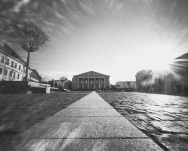 Black and white photo of a street with a distant building