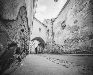 An atmospheric black and white picture showcasing a charming alleyway in Vilnius Old Town