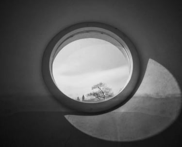 A monochrome image of a round window, showcasing contrasting shades of black and white