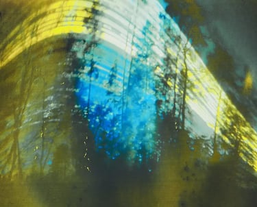 Sun path visible in blurry wood against blue sky