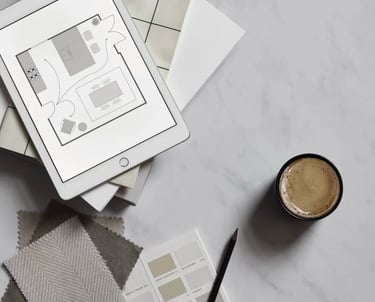 fabric samples alongside an ipad with a floorplan. Featuring a cup of coffee and a pencil