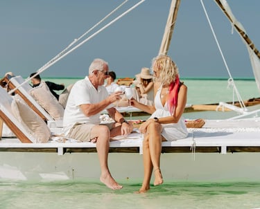 Un homme et une femme assis sur un voilier au bord de la plage avec de la famille et des amis