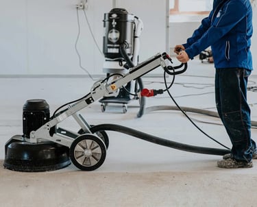 a man in a blue jacket is using a machine to clean the floor