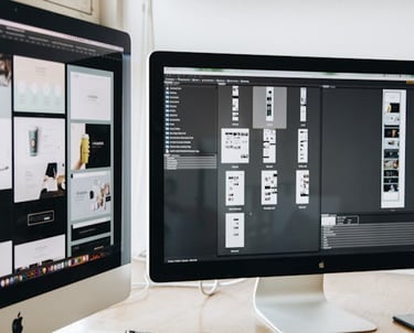 Two monitors displaying mockups for a website design