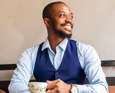 a man wearing a blue semi-formal attire holding a cup of tea