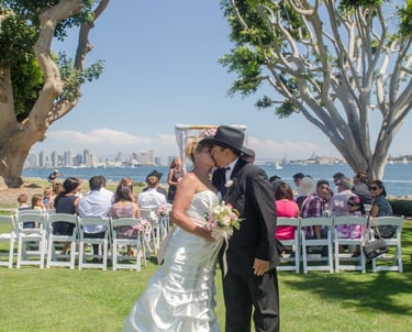 Bride & Groom kissing at wedding ceremony at Harbor Island park overlooking San Diego harbor