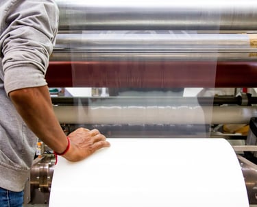 a man is holding a piece of paper and a roll stock