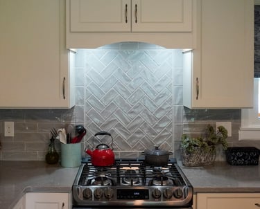 a stove with hood under the cabinet with LED lights to iluminate the wall backsplash