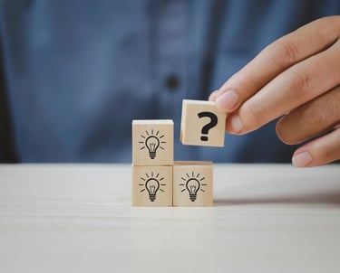 a person holding a wooden block with question mark