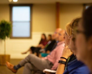an adult education classroom, people sitting in a row of chairs
