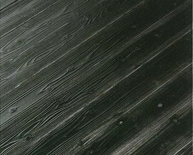 Dark charcoal gray wood grain texture on diagonal siding boards with visible knots.