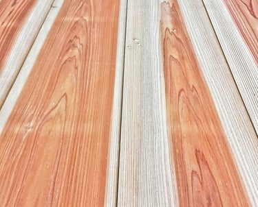 Close-up of natural sugi wood planks with unique orange and tan grain patterns for outdoor decking.