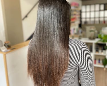 une femme aux cheveux longs après l'avoir lissés et une chemise à rayures