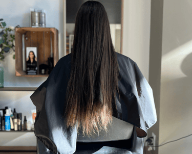 une femme assise sur une chaise avec ses cheveux avant de se lisser les cheveux sur une chaise