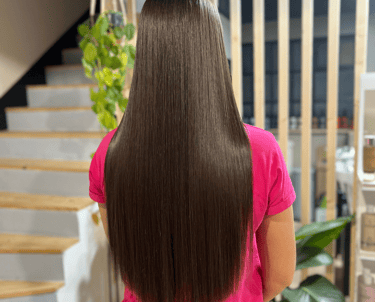 une femme assise sur une chaise avec ses cheveux après s'être lissé les cheveux sur une chaise