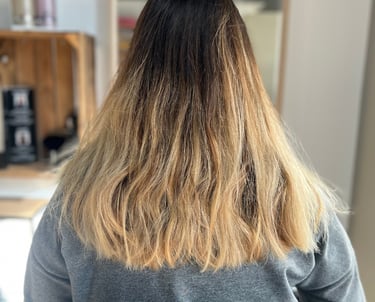 une femme aux cheveux blonds et au pull gris