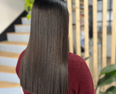 une femme aux cheveux longs et au pull-over rouge