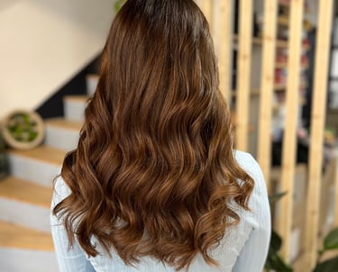 une féminin aux cheeux longs et à une chimise unise blanche