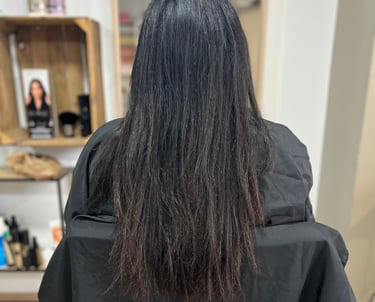 une femme aux cheveux longs avant l'avoir lissés et une chemise à rayures