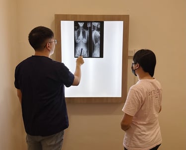 Chiropractor reviewing spine X-ray with patient at Sinisana Chiropractic.