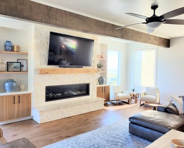Living room remodel with exposed beams, white stone work fireplace with natural wood mantle. Colorado Springs construction.