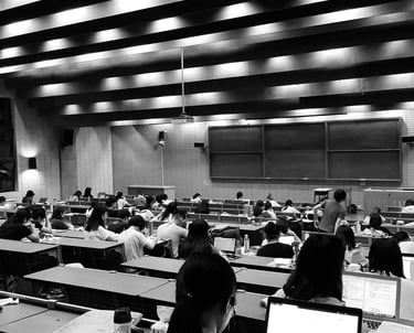 a university classroom with a lot of students sitting at desks