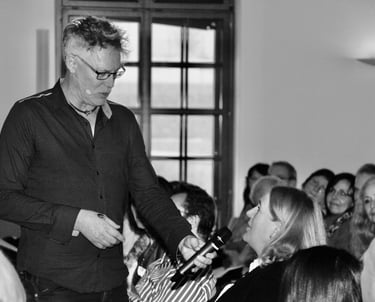 a man in a suit and tie is holding a microphone