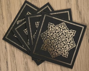 a set of four black and gold cards with a gold foiled design