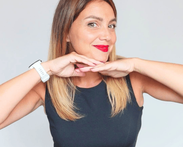 Formatrice en italien souriante, posant le menton sur ses mains, illustrant la page “Qui je suis” et