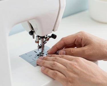 Close-up of a tailor carefully sewing a hem on a delicate fabric.