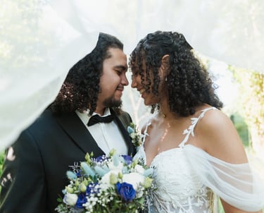 Un couple de mariés sous un voile blanc, mariage au Puy Saint bonnet