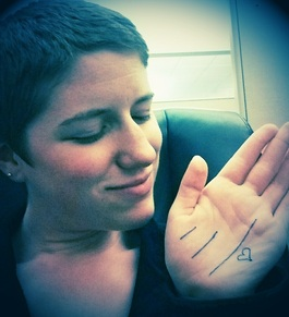 Melody looks lovingly at her palm, on which are drawn three lines of varying length and a heart.