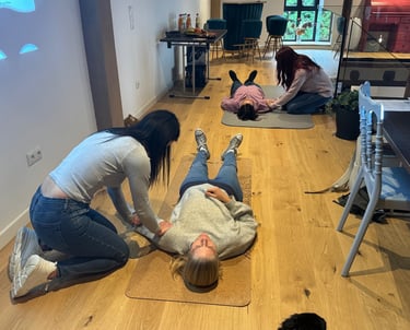 Zwei Menschen liegen auf einer Matte, während sie von anderen Menschen eine Shiatsu-Behandlung bekom