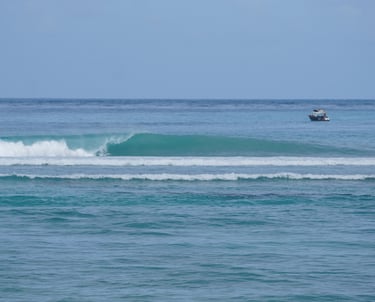 Fun left-hand wave at Ombak Toska with boats in background