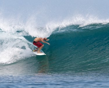 Surfer carving inside crystal clear barrel at Telescopes, Mentawai