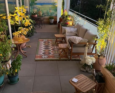 a patio with a couch and chairs and a rug