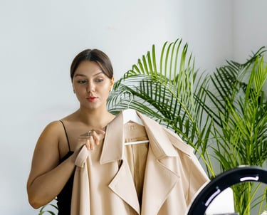 a woman in a black dress and a tan coat