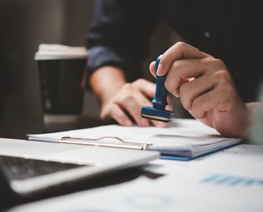 Pracownik stemplujący certyfikaty ukończenia kursu korekcji racic w biurze.