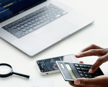 Pracownik dokonujący wyliczeń na laptopie w biurze.