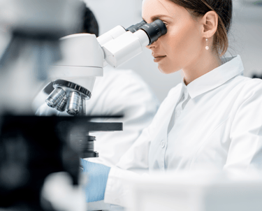 Naukowiec analizujący próbki pod mikroskopem w laboratorium badawczym.