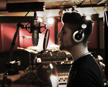 a man in a recording studio with headphones sings a song
